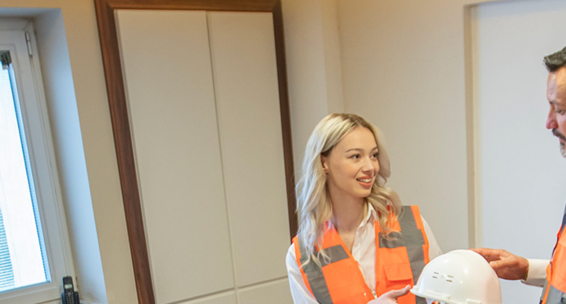 Trainer discussing hard hat with engineer