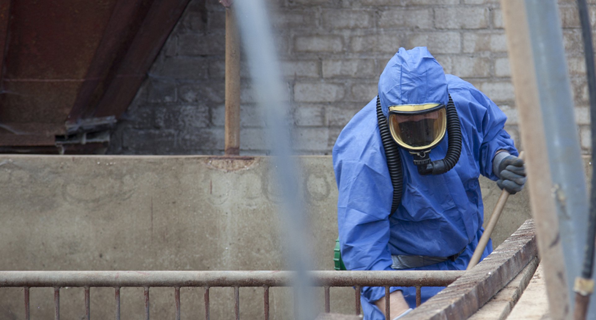 Man in blue suit conducting asbestos removal