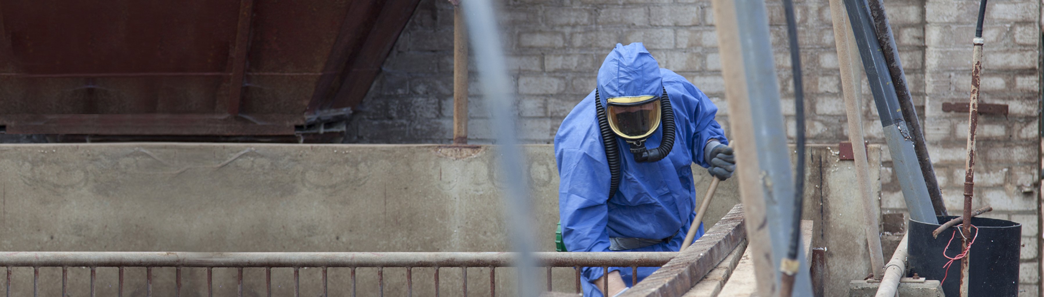 Man in blue suit conducting asbestos removal