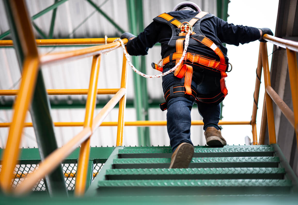 Construction Worker Wearing Safety Harness And Safety Line Working At High Place