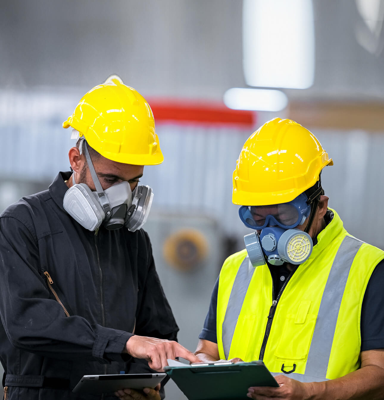 Two officers wearing gas masks, holding tablet and book, inspect the chemical spill site in an industrial warehouse to assess the damage, wearing gas masks, inspecting and evaluating toxicity of leak.
