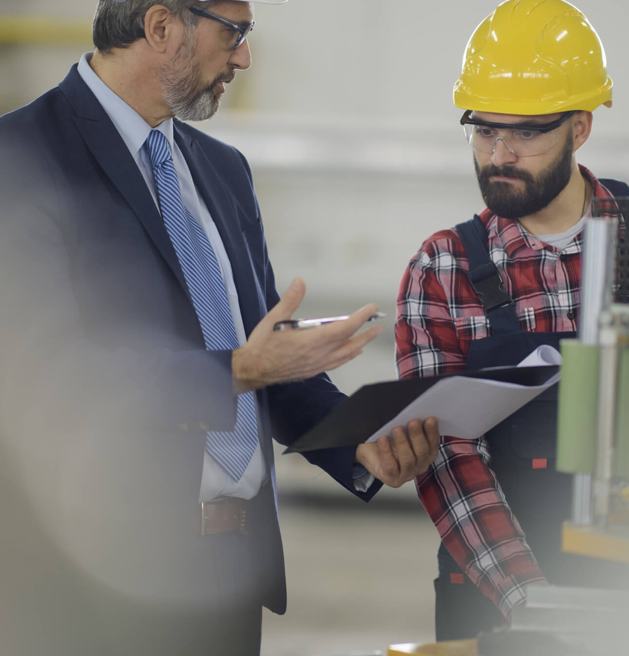 Young employee with health and safety consultant in factory