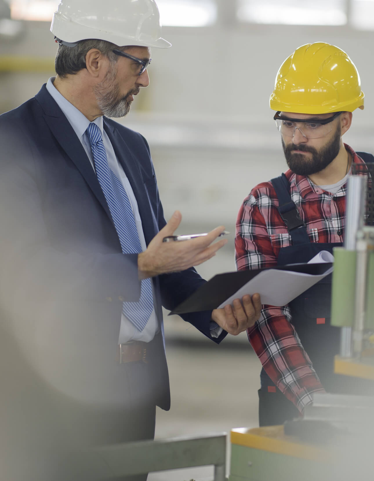 Young employee with health and safety consultant in factory Young employee with health and safety consultant in factory