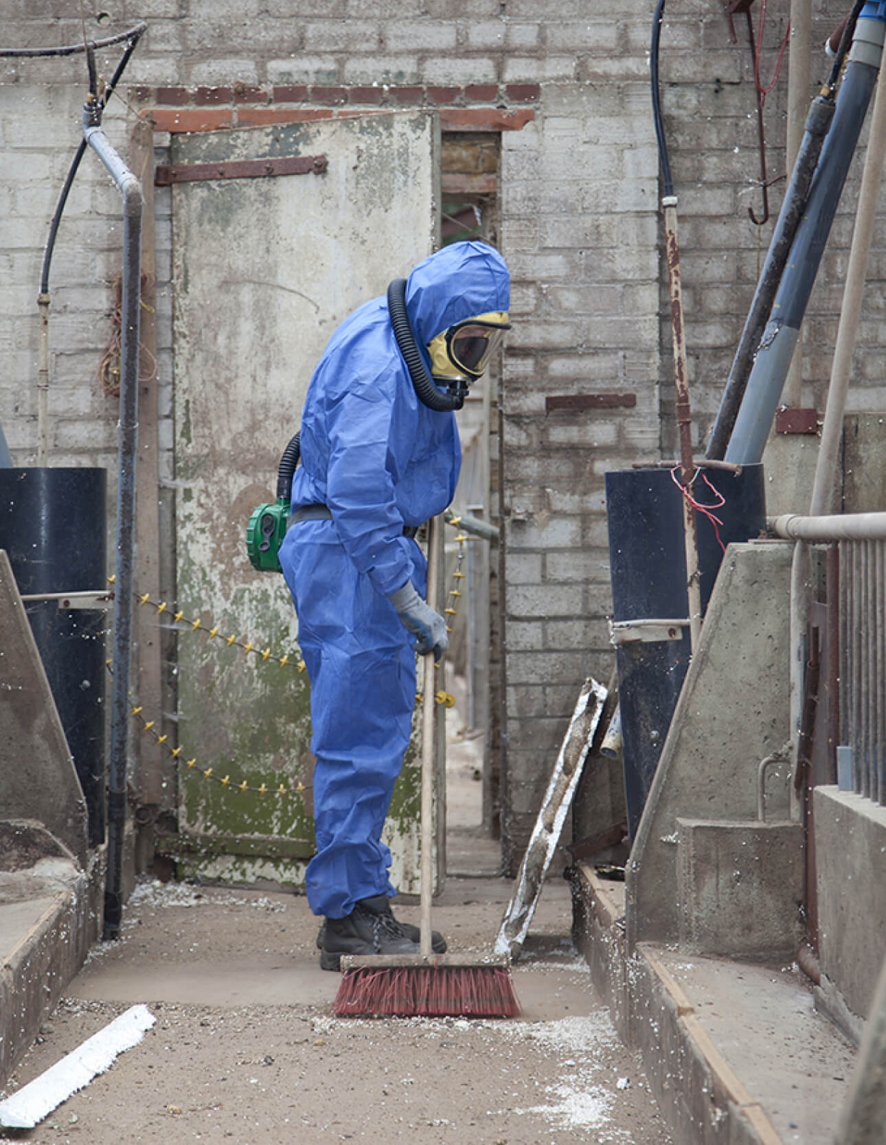 Man in blue suit conducting asbestos removal Man in blue suit conducting asbestos removal